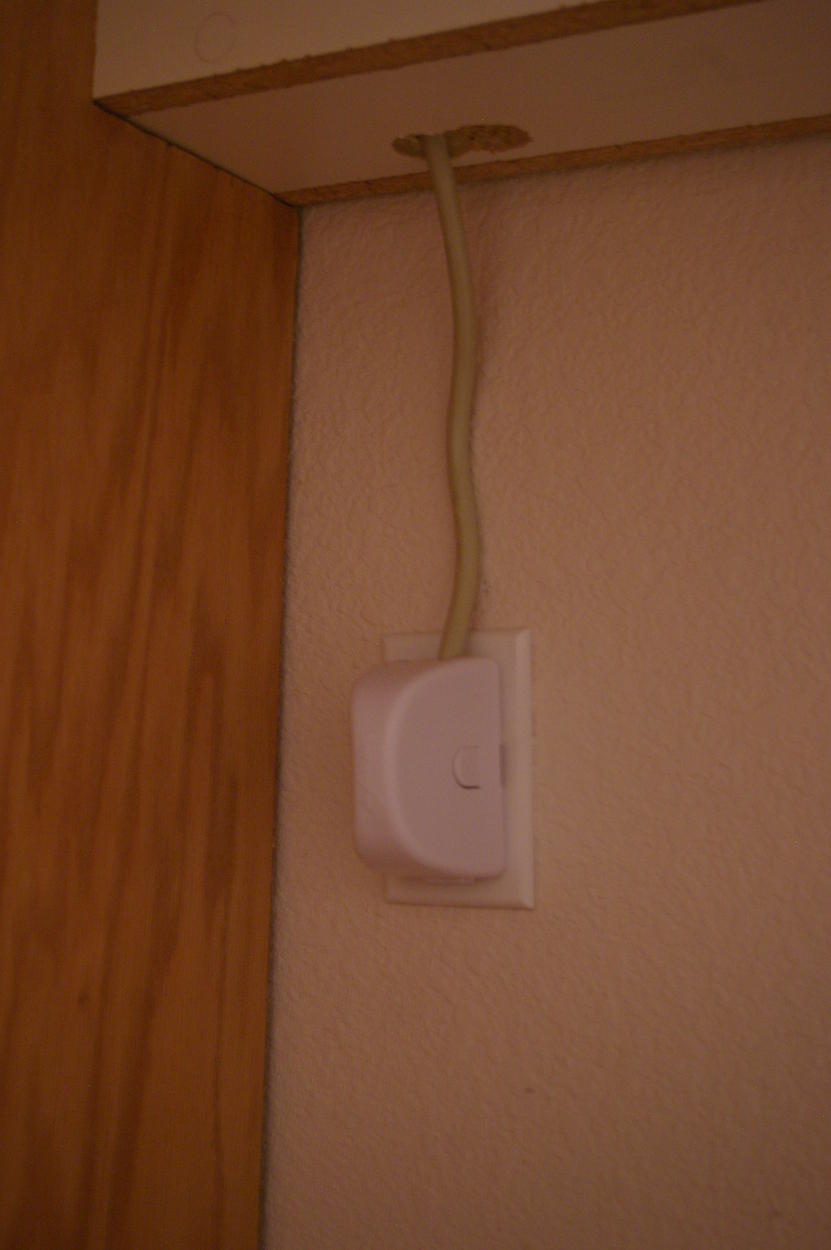 Baby Proofing - Outlet cover with power strip cord coming from channel